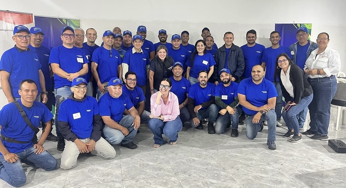 Belkis Araque junto a un equipo de trabajo en una capacitación corporativa